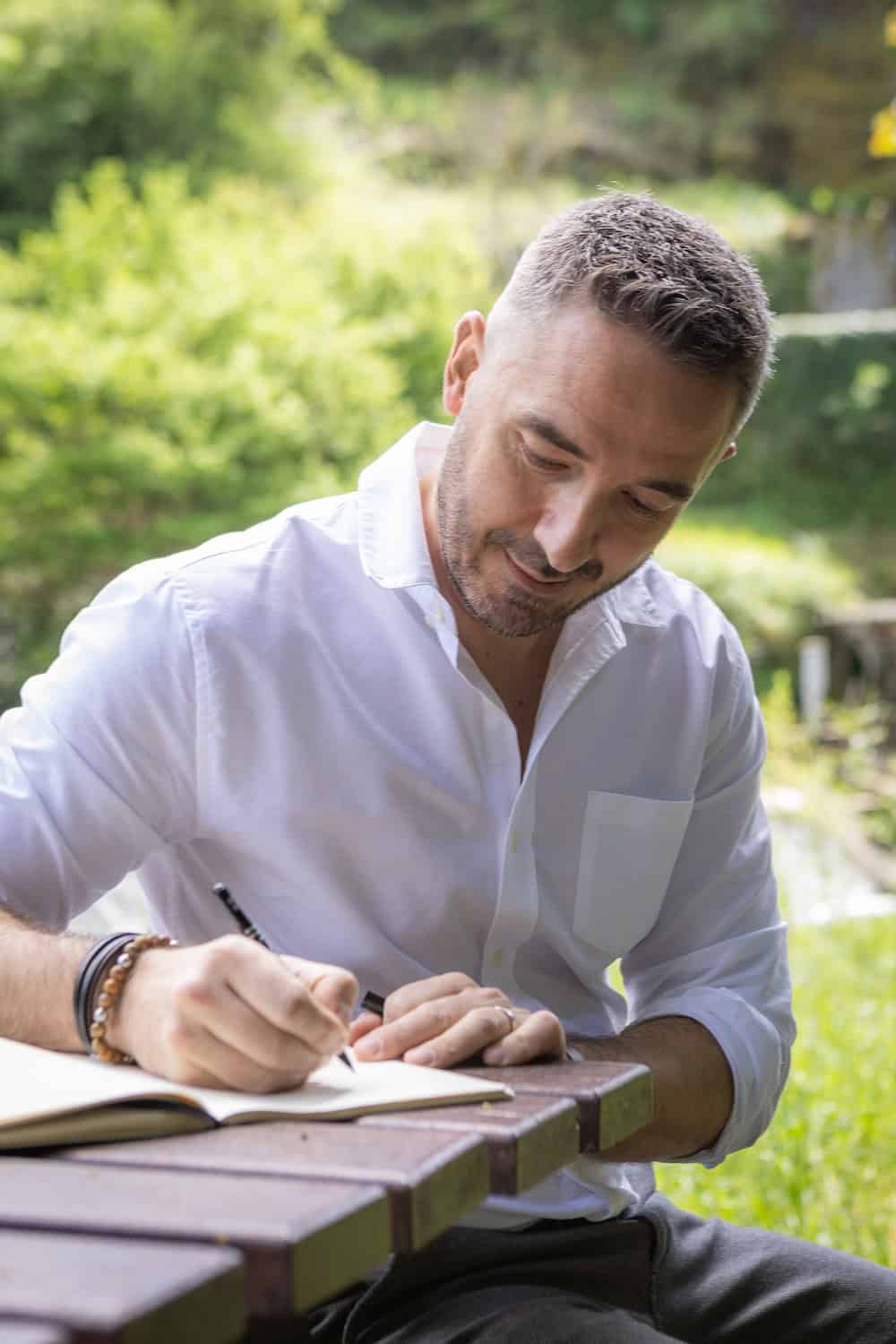 Etienne Couzinier, qui écrit dans son carnet. Coach professionnel dans le Tarn : accompagnement en présentiel et distanciel des particuliers et des structures médico-sociales